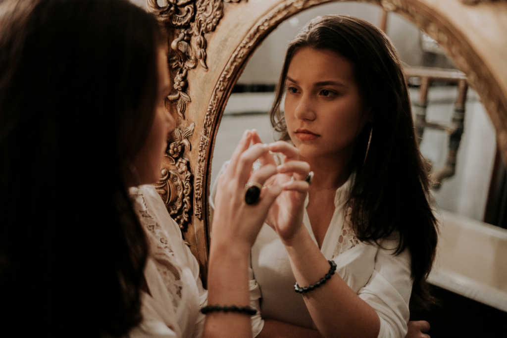 woman looking into mirror